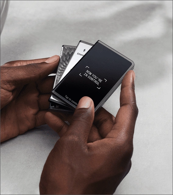 Hands fanning out multiple Ledger signers with one displaying the text now you're in control.