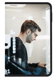 Photo of man working in a work pod framed by a Ledger signer device